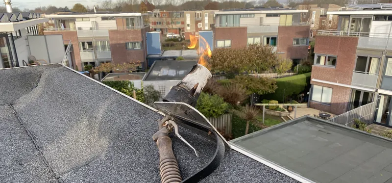 Bitumen dakbedekking wordt met de brander aangebracht en de naden worden dichtgebrand.