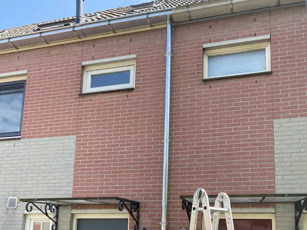 Nieuwe zinken regenpijp aan de voorgevel.