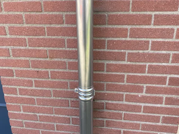Zinken hemelwaterafvoer met beugel.