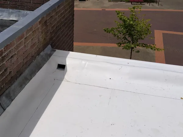 PVC-dakbedekking met opstand tegen het metselwerk.